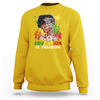 Adult crewneck sweatshirt, yellow, front graphic with face and text “Education is Freedom”.