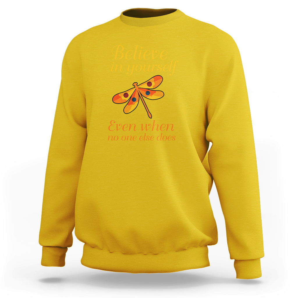 Mustard yellow dragonfly graphic sweatshirt with “Believe in yourself” front text and long sleeves.