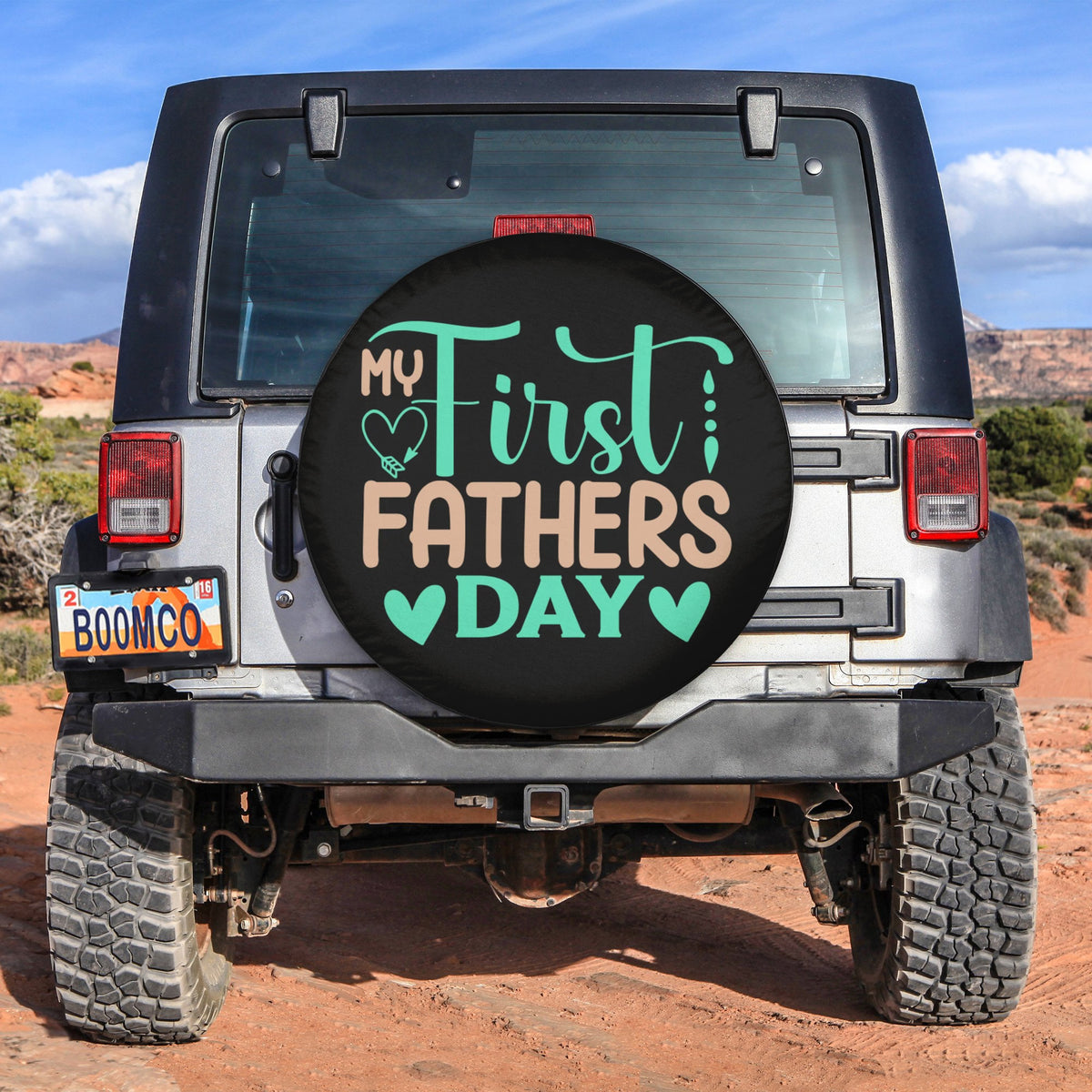 Spare tire cover with black circle design reading "My First Fathers Day"