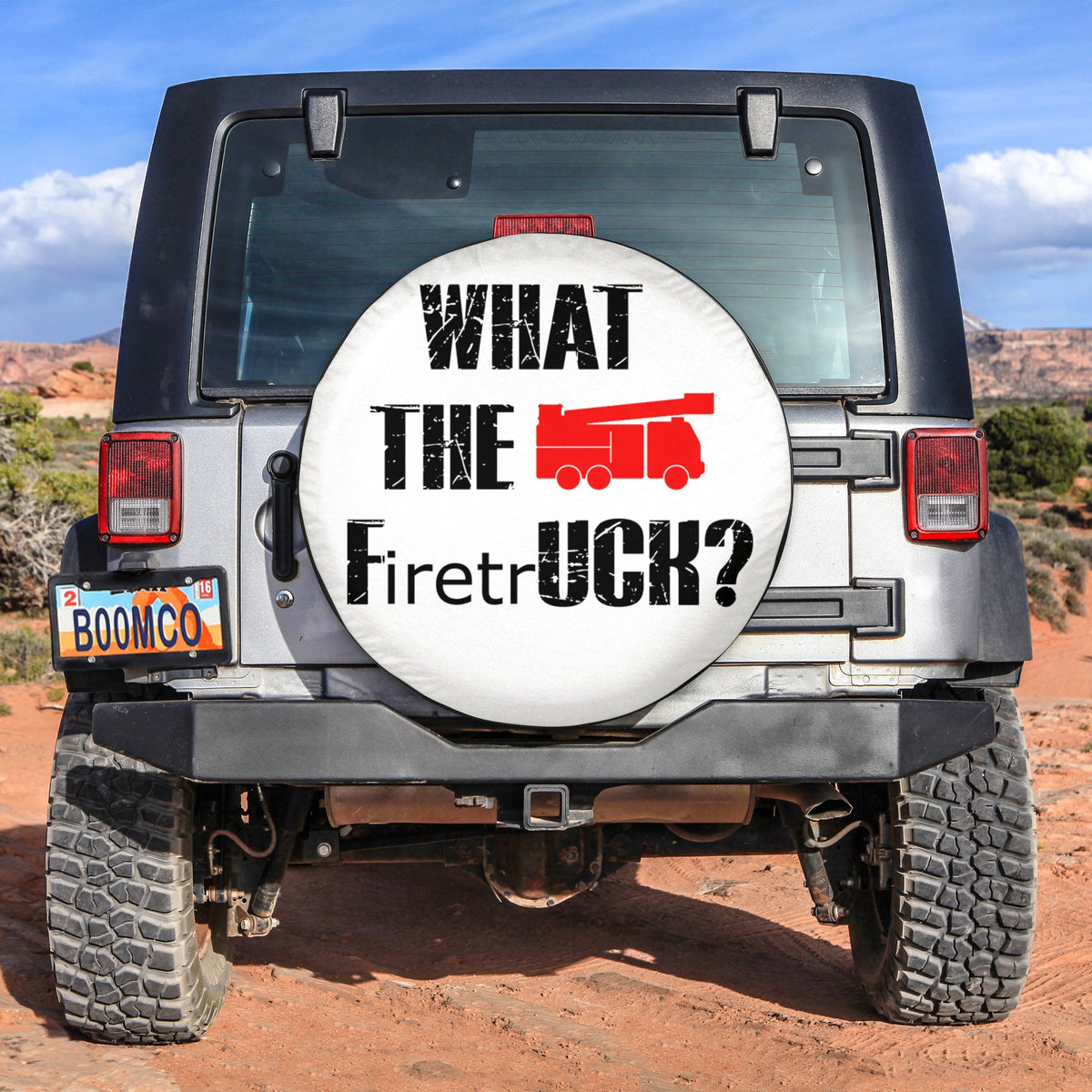 Round spare tire cover with 'What the FiretrUCK?' text and red truck graphic