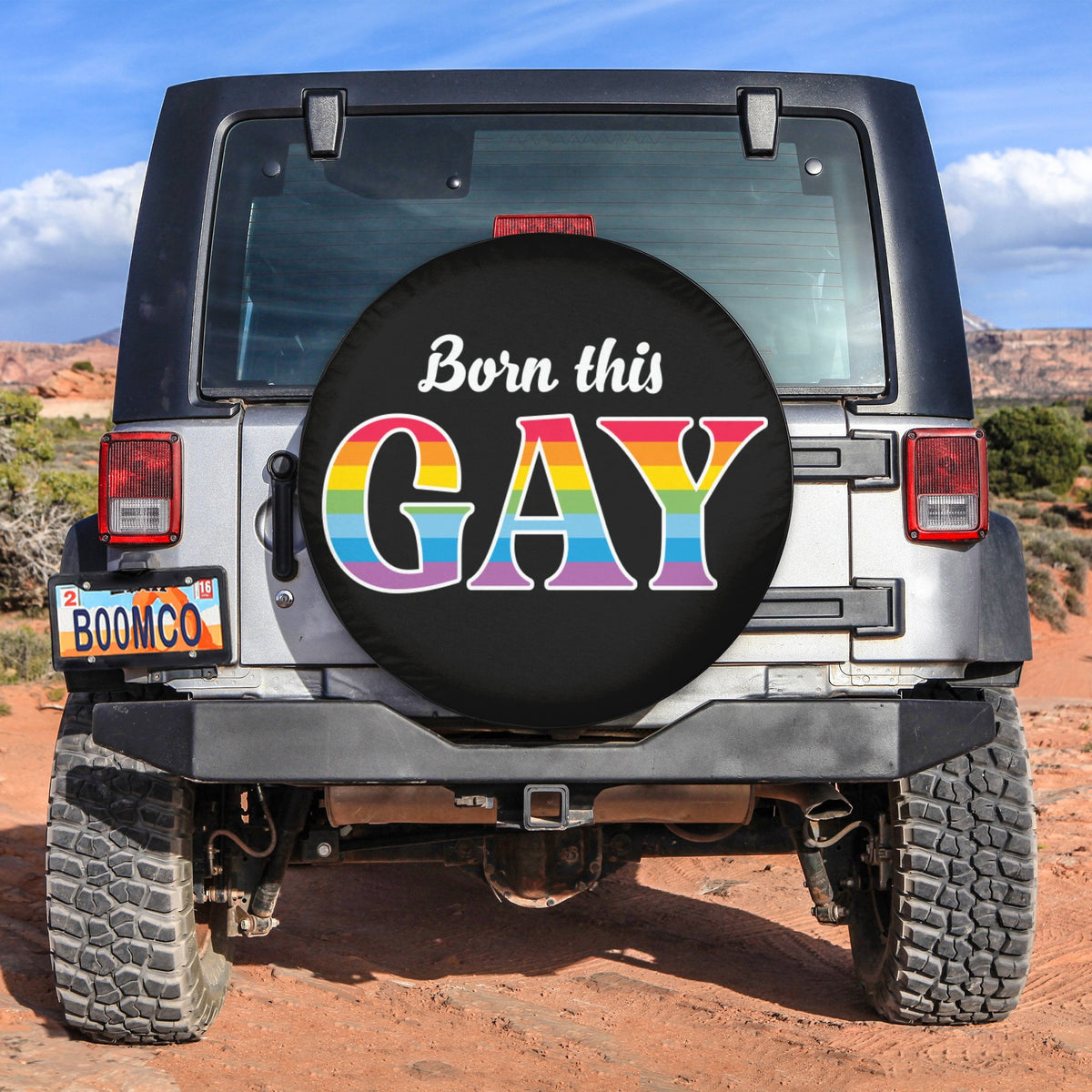 Black spare tire cover with colorful "Born this GAY" design and rainbow letters