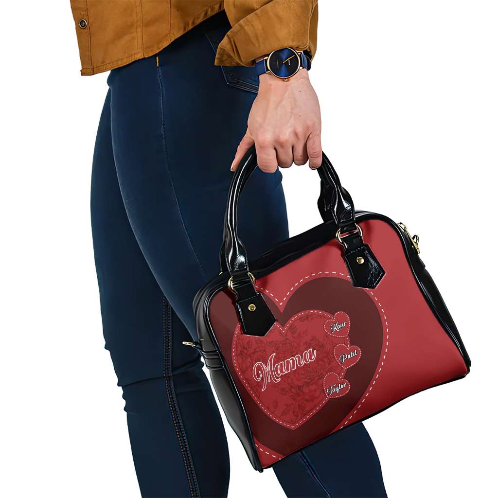 Red heart patch handbag with black top handles and visible strap hardware