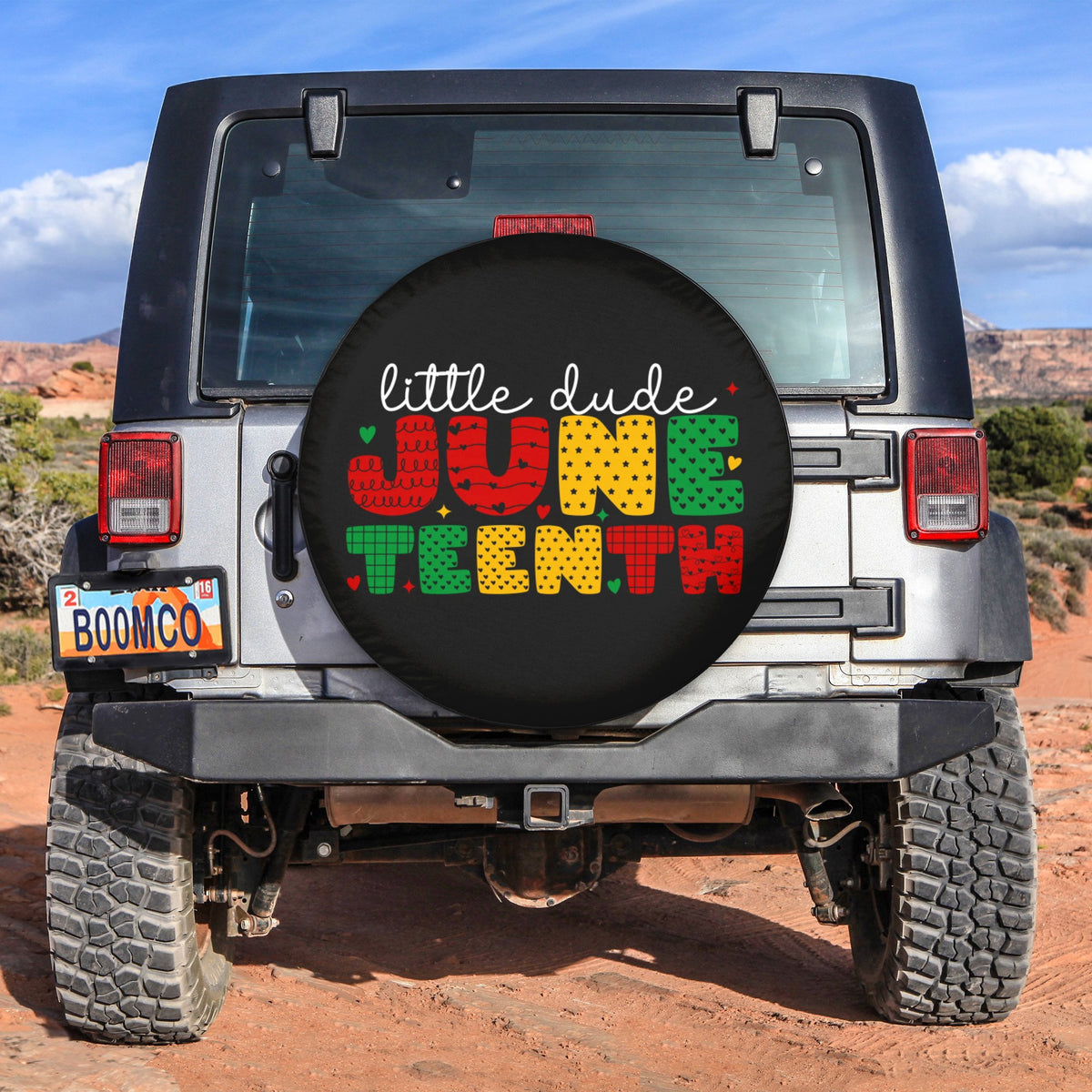 Spare tire cover with black background and colorful Juneteenth "little dude" text