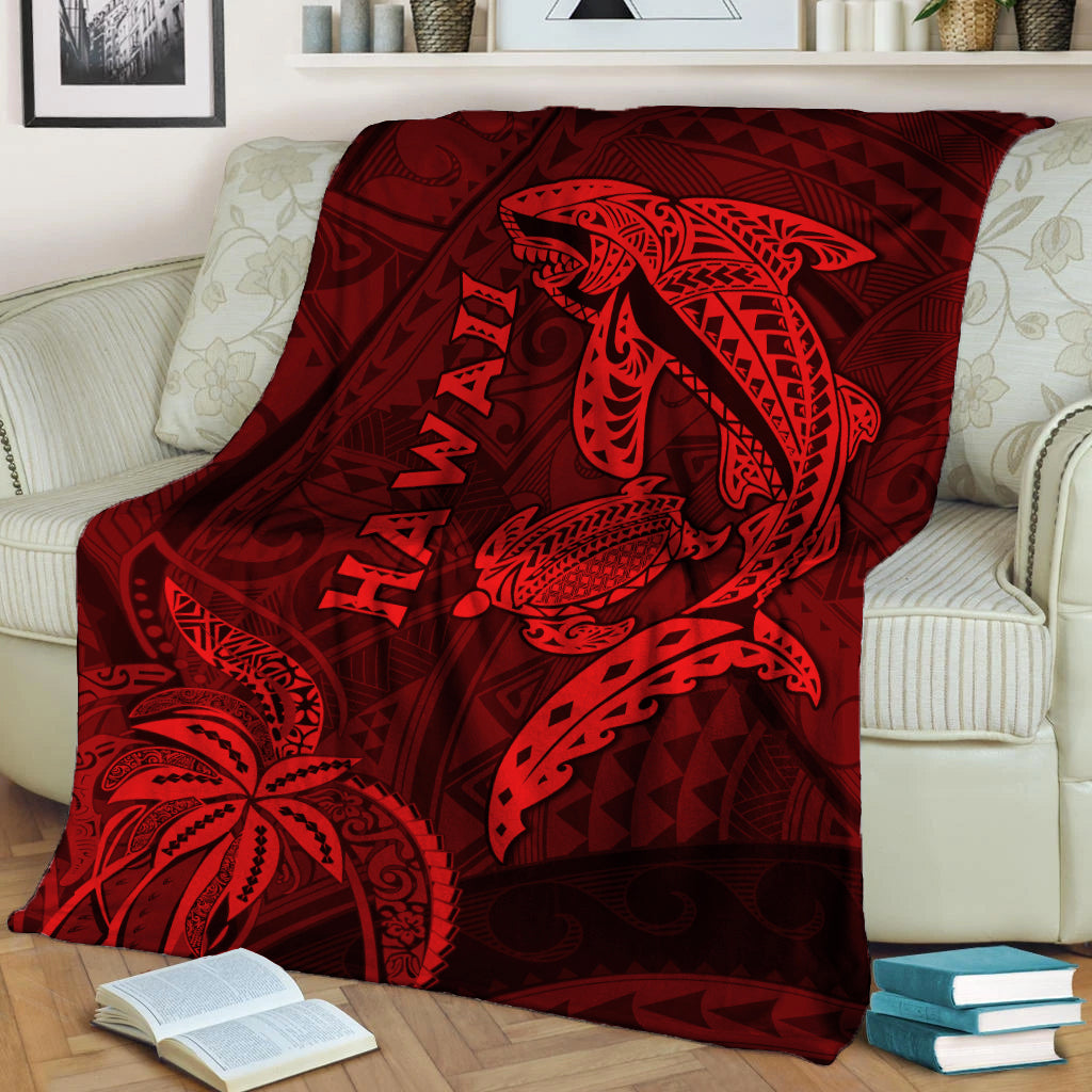 Red blanket with shark and turtle Hawaiian motif, draped on sofa