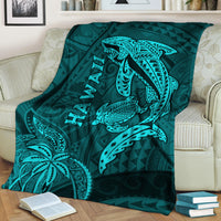 Turquoise shark and turtle blanket with Hawaii text tribal design, draped on sofa.