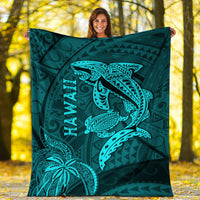 Turquoise shark and turtle blanket with Hawaii text tribal pattern, held up outdoors.