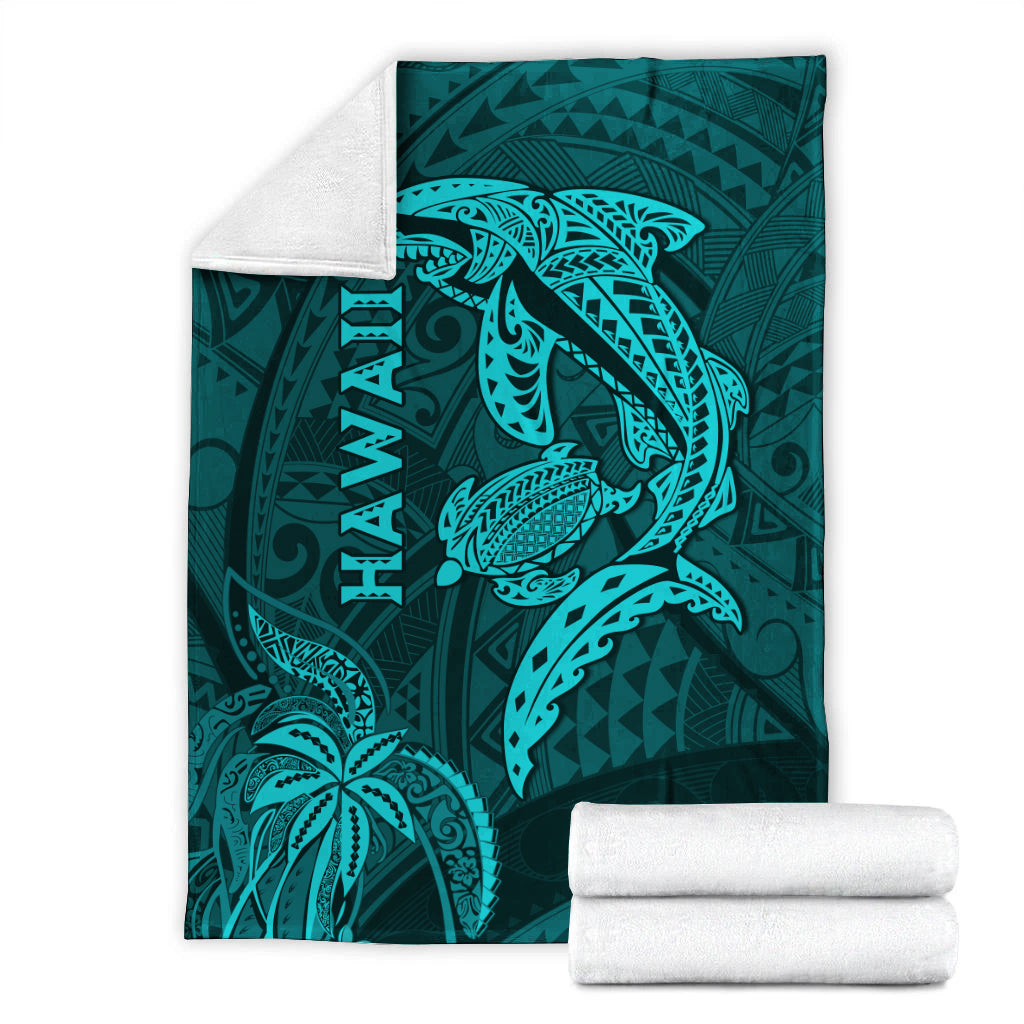 Turquoise shark and turtle blanket with Hawaii text tribal design, with folded towels.