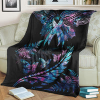 Black throw blanket with colorful butterfly and feather pattern, folded on a couch