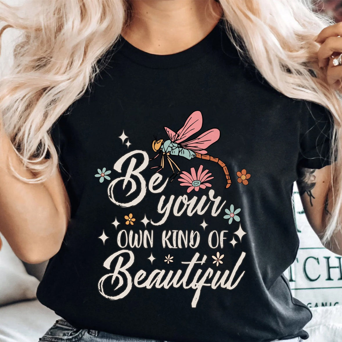 Black crewneck T-shirt with 'Be your own kind of Beautiful' dragonfly design.