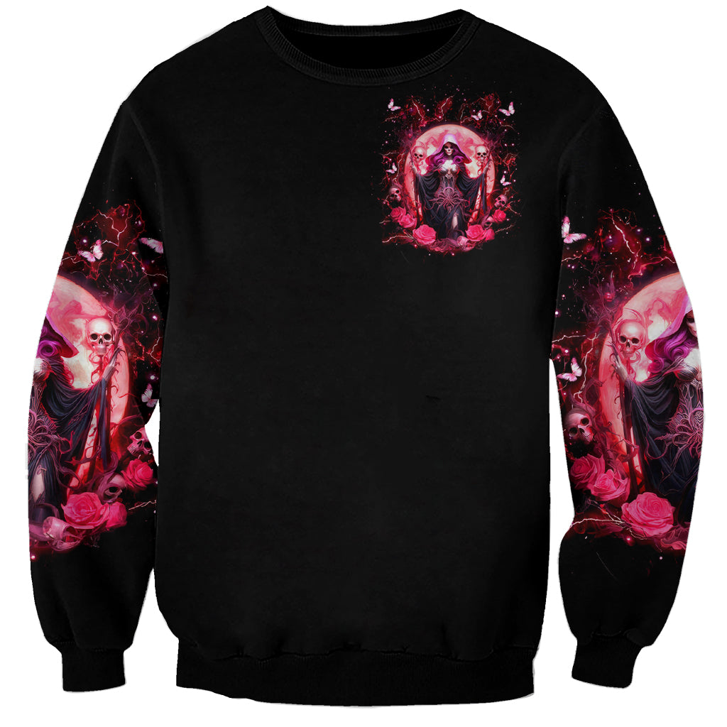 Black unisex sweatshirt with small pink witch skull chest print and red sleeve splash