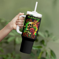 Black tumbler with white handle and straw in hand; skull and rose graphic front