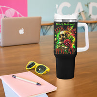 Black tumbler on desk with handle and straw; skull and rose graphic on front