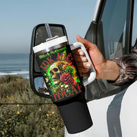Black tumbler with handle and straw held in a hand; skull and rose graphic