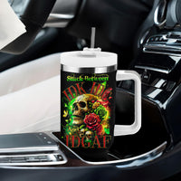 Black tumbler with white handle and lid in car; skull and rose graphic on front
