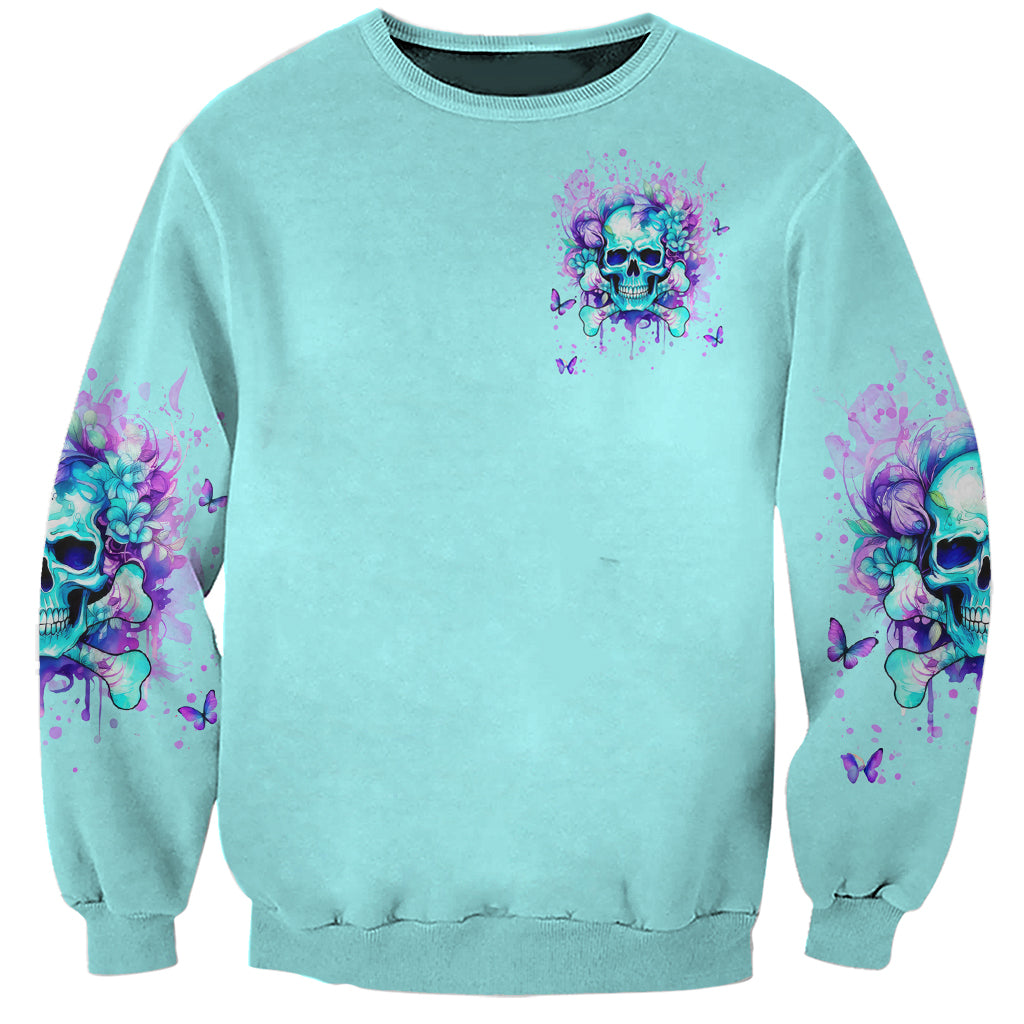 Unisex teal crewneck sweatshirt with small purple flower skull chest print and sleeve art