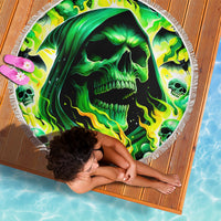 Round beach blanket featuring a green flame skull print and white fringed border