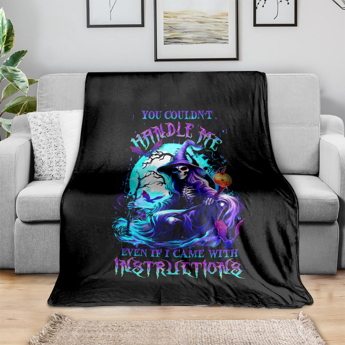 Black witch skull blanket with colorful mystical portrait print, draped over couch