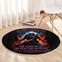 Black round rug with warrior skull artwork and “old people” themed slogan