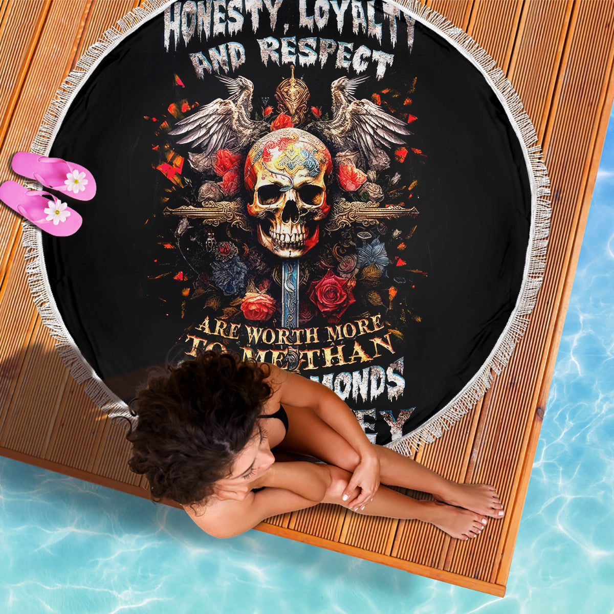 Black round beach blanket with skull, wings, roses and fringed edge; honesty loyalty text