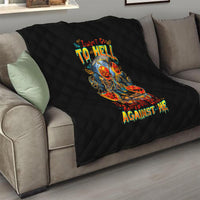 Black quilted blanket with skull-and-devil graphic on a sofa