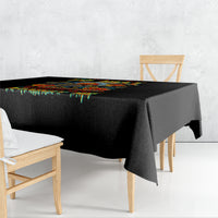 Black square tablecloth with colorful dripping pattern along the top edge.