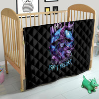 Black quilt blanket with quilted diamond pattern and purple-blue witch skull design on crib rail