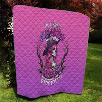 Pink quilted blanket with diamond pattern and central witch-skull graphic