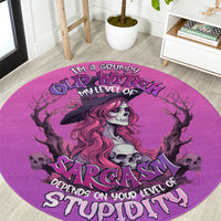 Round pink rug with witch silhouette, skull accents, and 'Sarcasm' typography
