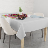 White tablecloth with multicolor drip border and colorful skull-themed centerpiece