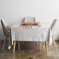 White tablecloth with multicolor dripping stripe border on a square table