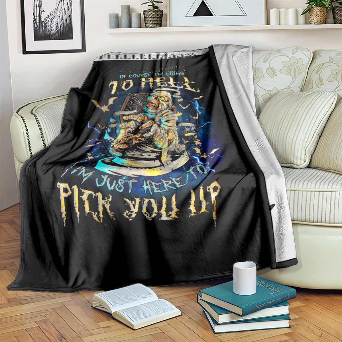 Black mummy skull graphic blanket draped on sofa with blue lightning, paired with light throw
