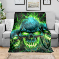 Skull flame graphic blanket in green and teal, draped over a grey couch