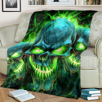 Skull flame graphic blanket, teal skull with bright green flames, draped across chair