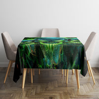 Black tablecloth with green-blue skull graphic covering square dining table