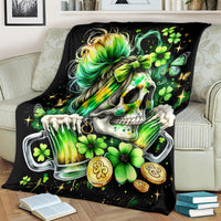 Black throw blanket close view: skull, green hair, clovers, and drink can artwork