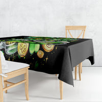 Black tablecloth draped over dining table edge, green skull and shamrock print