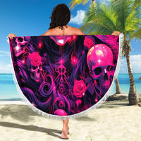 Skull-and-rose round beach blanket with fringed border, held open outdoors