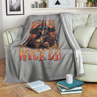 Gray witch skull blanket on sofa, featuring 'WEE BIT WICKED' flame print