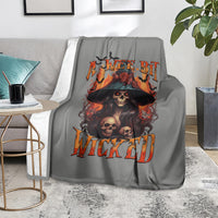 Gray witch skull blanket on armchair with orange flame 'WICKED' graphic