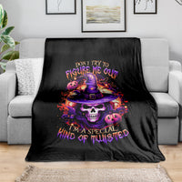 Black skull witch graphic throw blanket with colorful text design, draped on sofa