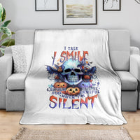 White throw blanket with blue bat skull graphic and Halloween text, on sofa