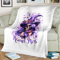White Halloween witch skull hat blanket with purple artwork and “Haunt Mess” text, on couch
