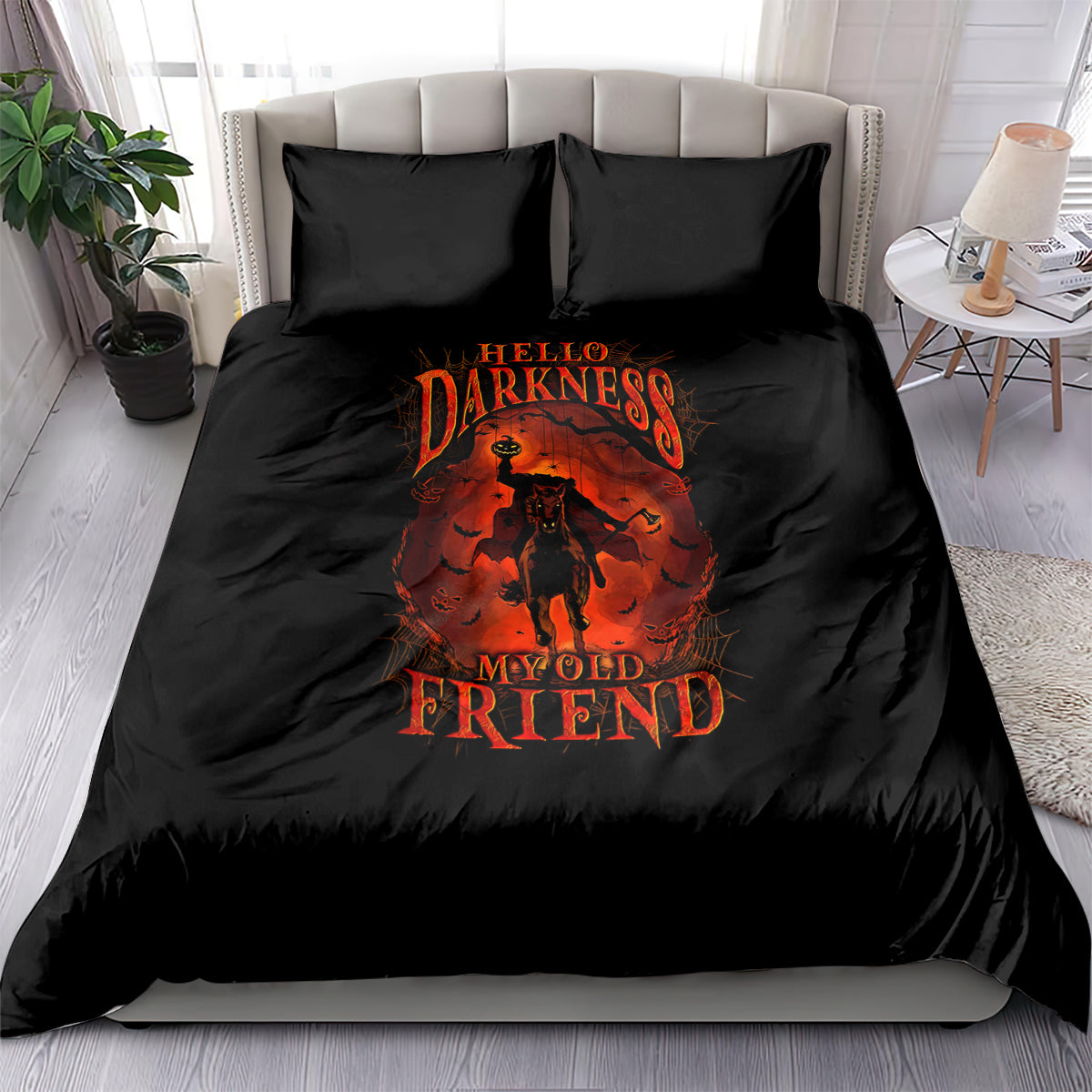 Black bedding set with orange graphic skull-style figure on duvet and two matching pillows