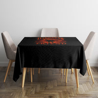 Black tablecloth with orange jack-o-lantern skull graphic on square dining table
