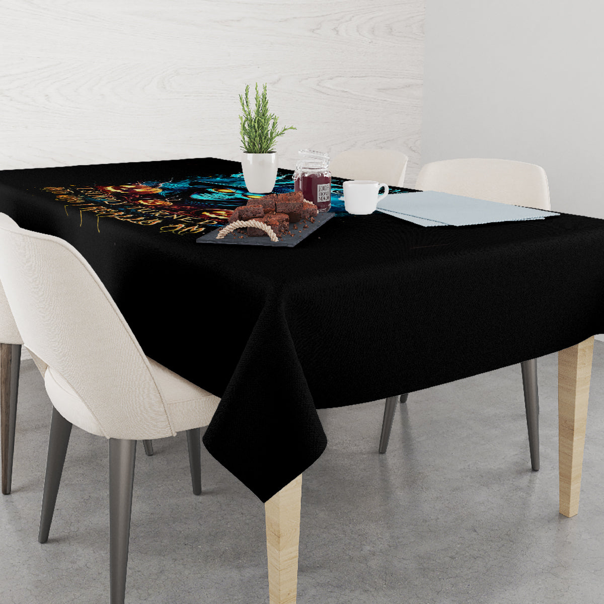 Black Halloween tablecloth with skull design, cloth corners hanging over dining table