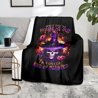 Black Halloween blanket on living room sofa with colorful wizard skull and purple text