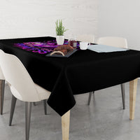 Black tablecloth with purple skull graphic on tabletop, hanging over edges