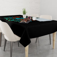 Black tablecloth with colorful witch skull artwork, spread across a dining table