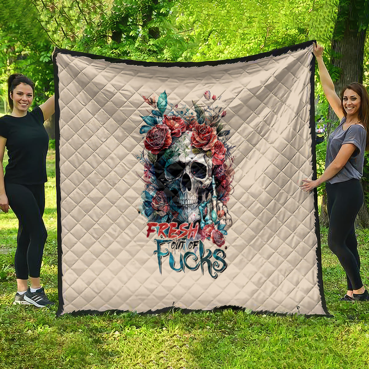 Beige quilt hung outdoors with diamond stitching and floral skull, FRESH out of FUCKS text