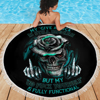 Black round beach blanket with fringed edge, teal skull rose artwork and text